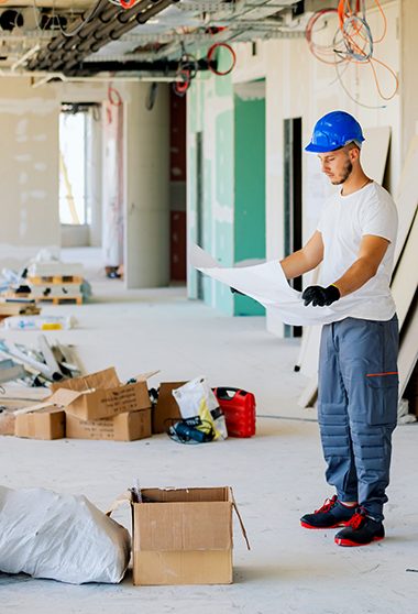 Artisan avec plan sur un chantier d'habitation